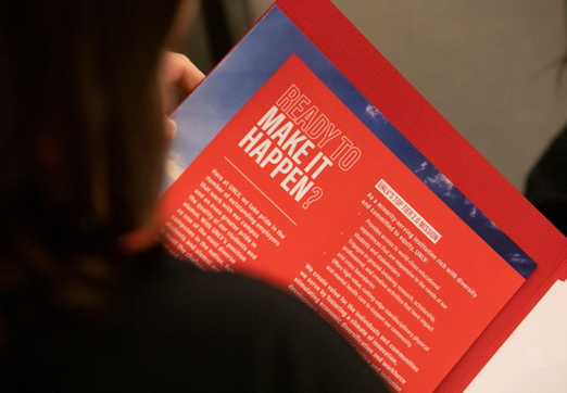 Person holding flyer with header "Ready to Make it Happen?"