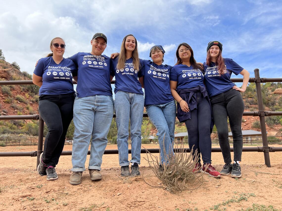 Group of students wearing purple shirts, "Alternative Breaks Trip"