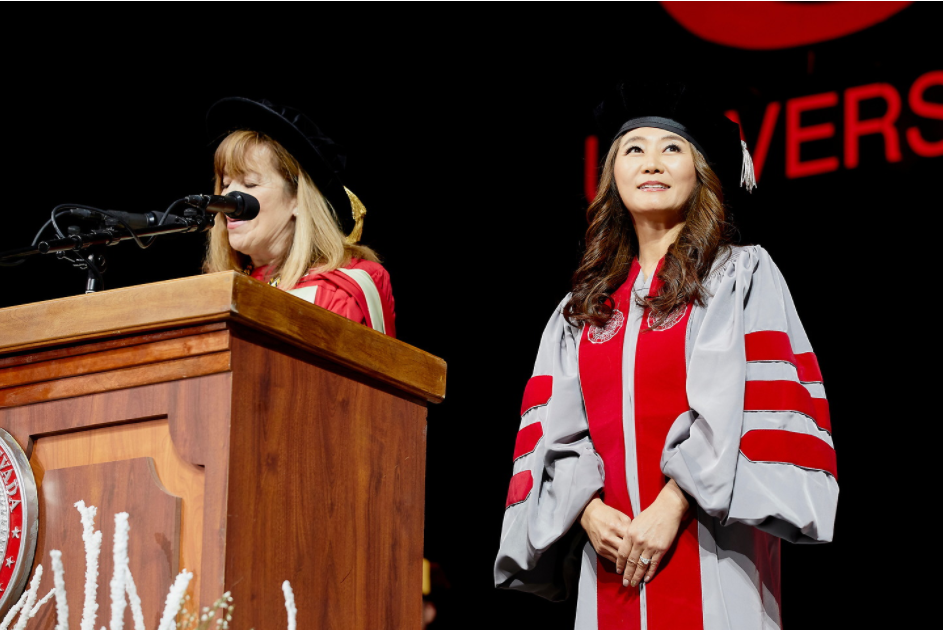 two women graduates on a podium 