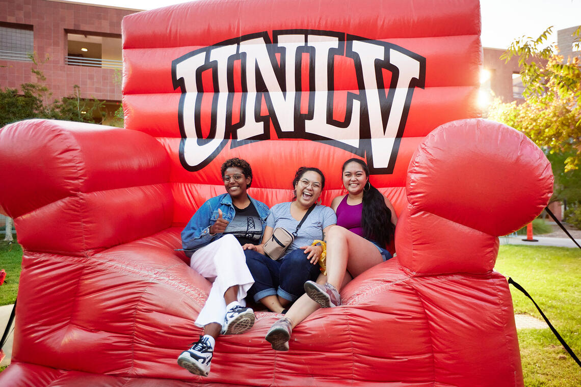 Three people sitting down on an inflatable chair