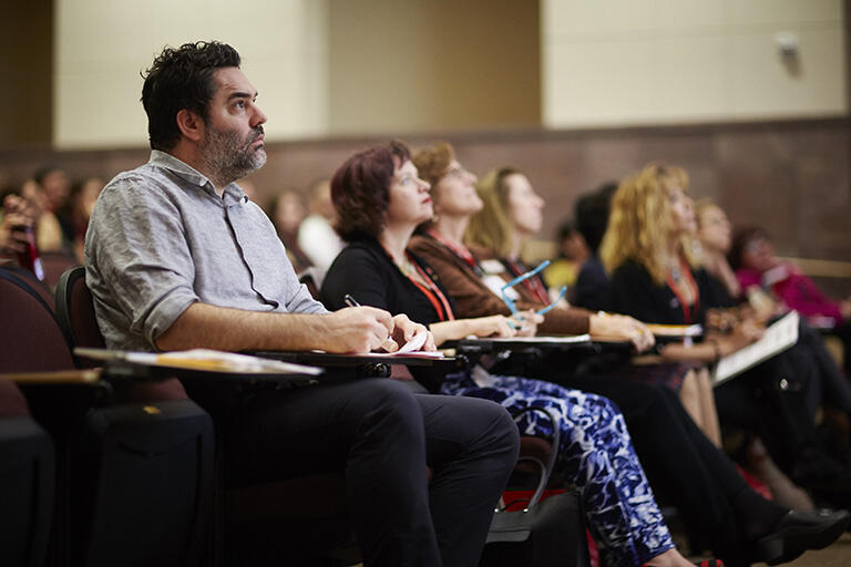 Students in a lecture hall looking 