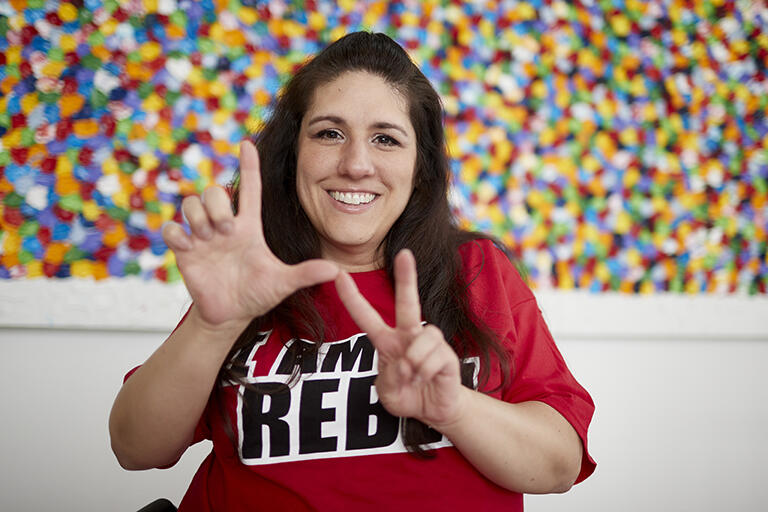 Person wearing red showing LV hand signs