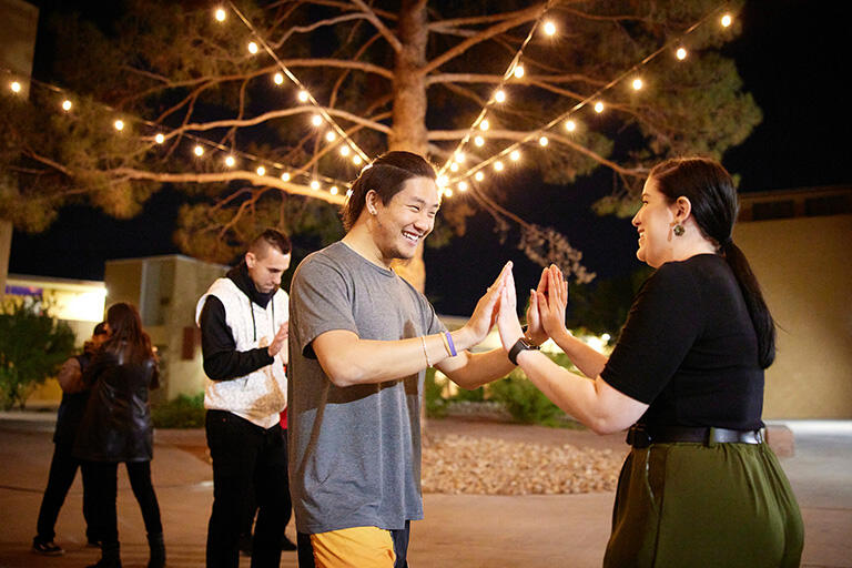three people playing a game with hand gestures