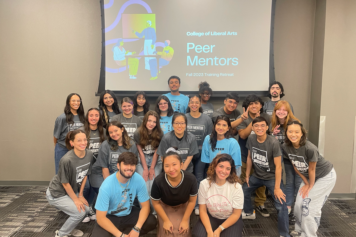 a group of students posing for a photo infront of a projector screen