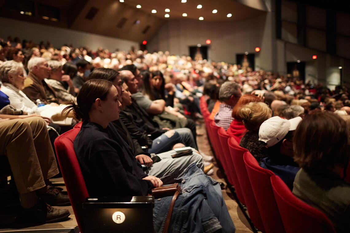 side view of people seated in a theatre