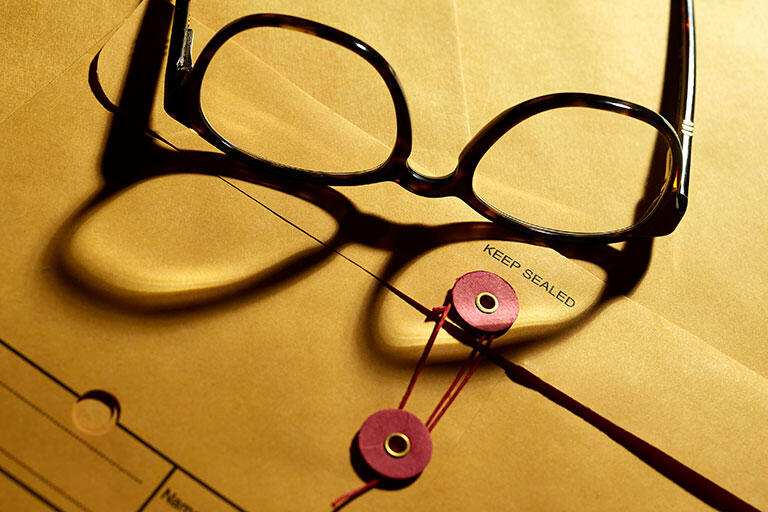 A pair of glasses on a manila clasp envelope