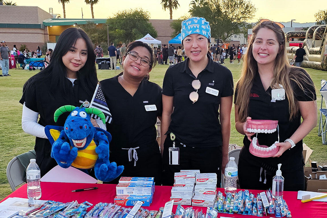 Four students at a table booth outside