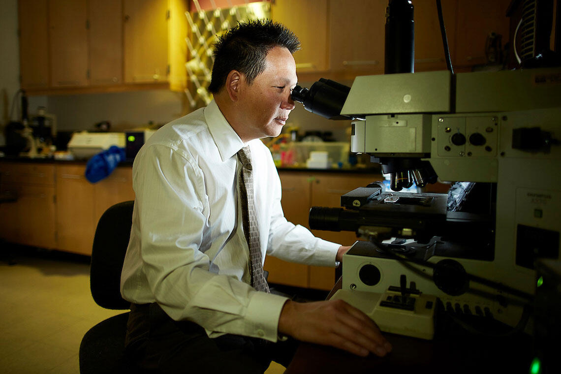 A man looking through a microscope