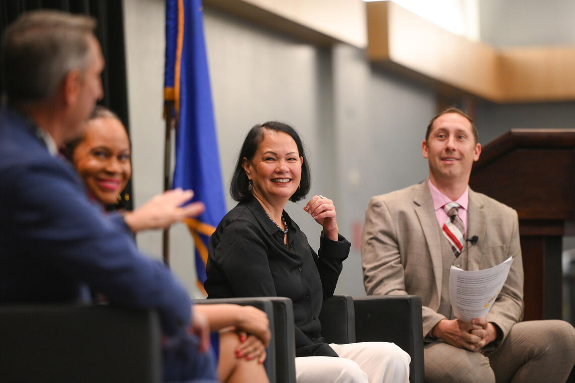 Four people gathered near a blue flag