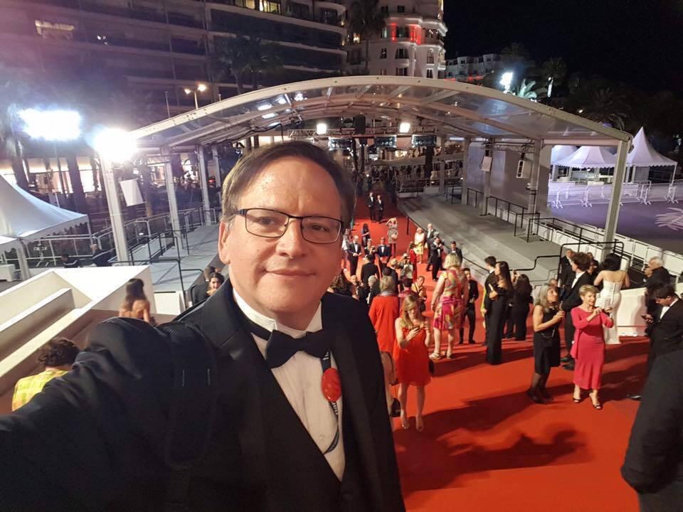 Photo of Prof. Francisco Menéndez looking into camera and a red carpet behind him