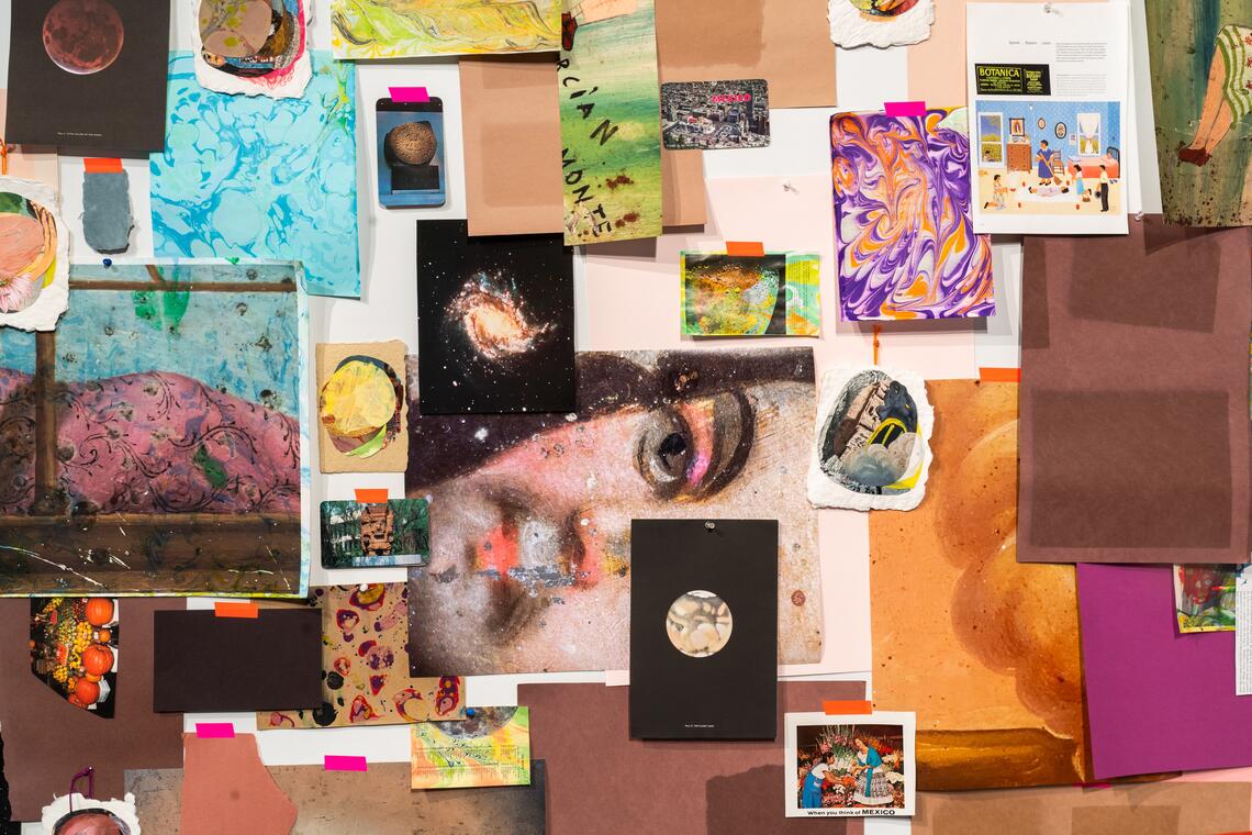 A mass of paper sheets has been pinned and taped to a wall. We see a wealth of things: a postcard of a city labelled “Mexico,” a photo of a circular Mesoamerican stone artifact, a picture of a galaxy, marbled paper, a cropped image of a painted human face, collages made from overlapping circles, a photo of spherical fruit and vegetables (pumpkins, lemons) — circles and spheres occur again and again.