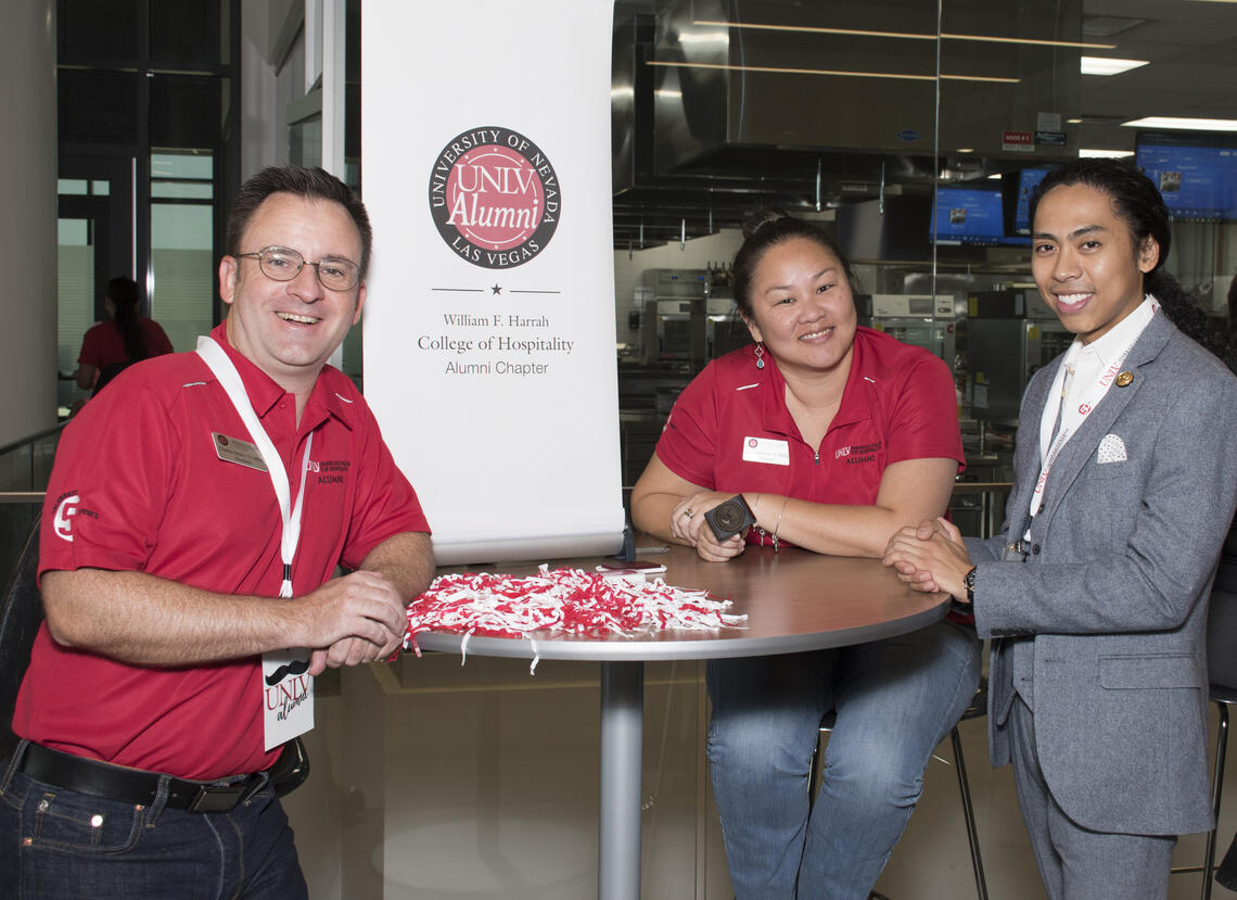 three people on a table smiling for the photo
