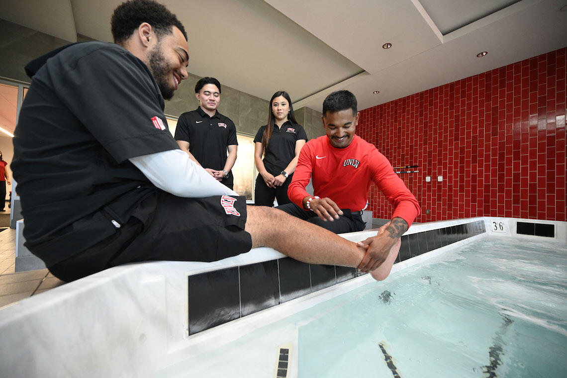 A man holding a person's foot to dip into water