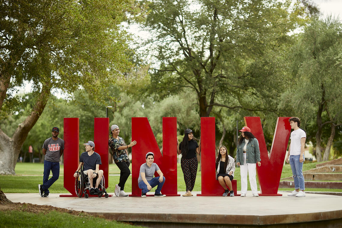 People standing around big letters spelling UNLV