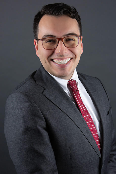 A man with glasses smiling.