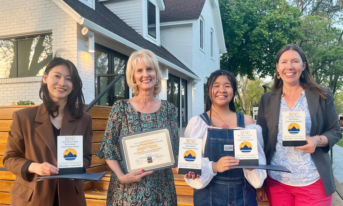 Four women smiling at the camera holding award certificates.