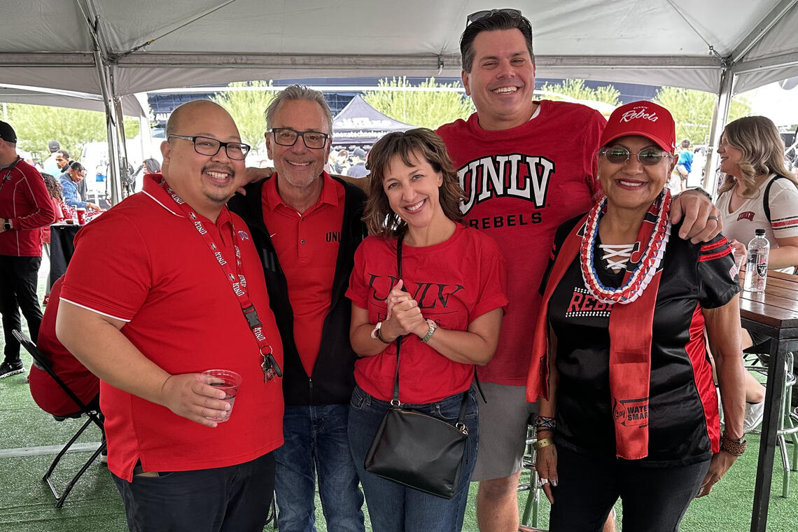 Five people wearing red and posing for a photo