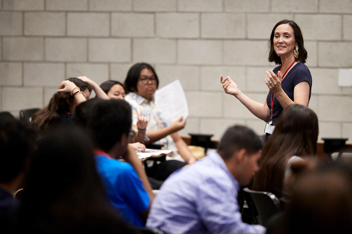A teacher engages with a group of students in a classroom.