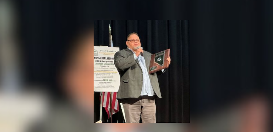 Photo of Danny Ortega winning an award and holding a microphone giving a speech