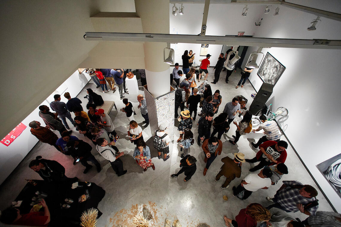 aerial photo of the interior of the UNLV Donna Beam Gallery with lots of art and people below