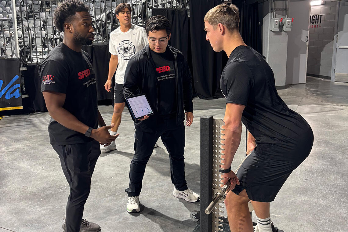 Two men observing a person weightlifting a barbell