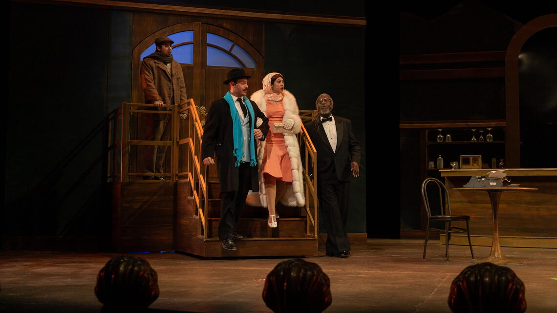 Theatre play of a man is helping a women down steps while another man whistles
