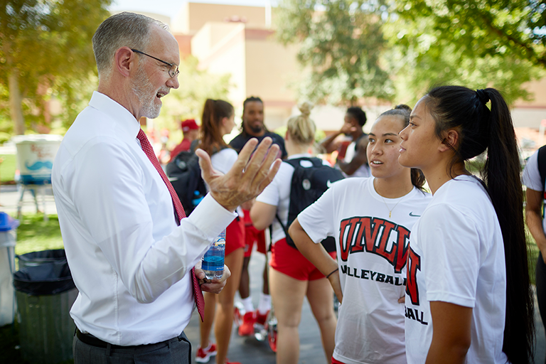 President Heavey speaking with a group of students