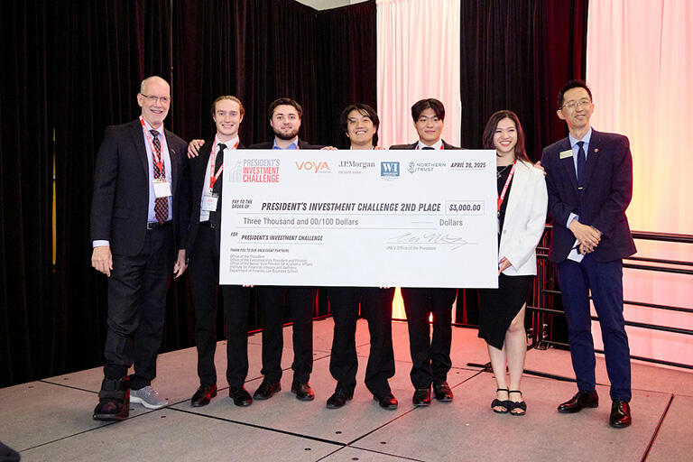 Group of students holding a large check