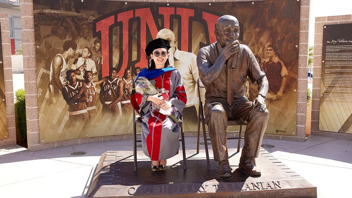 Student seated next to Jerry Tarkanian statue