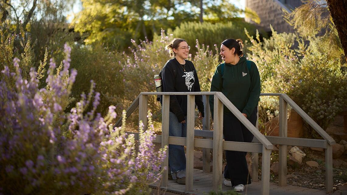 Two students walking through garden
