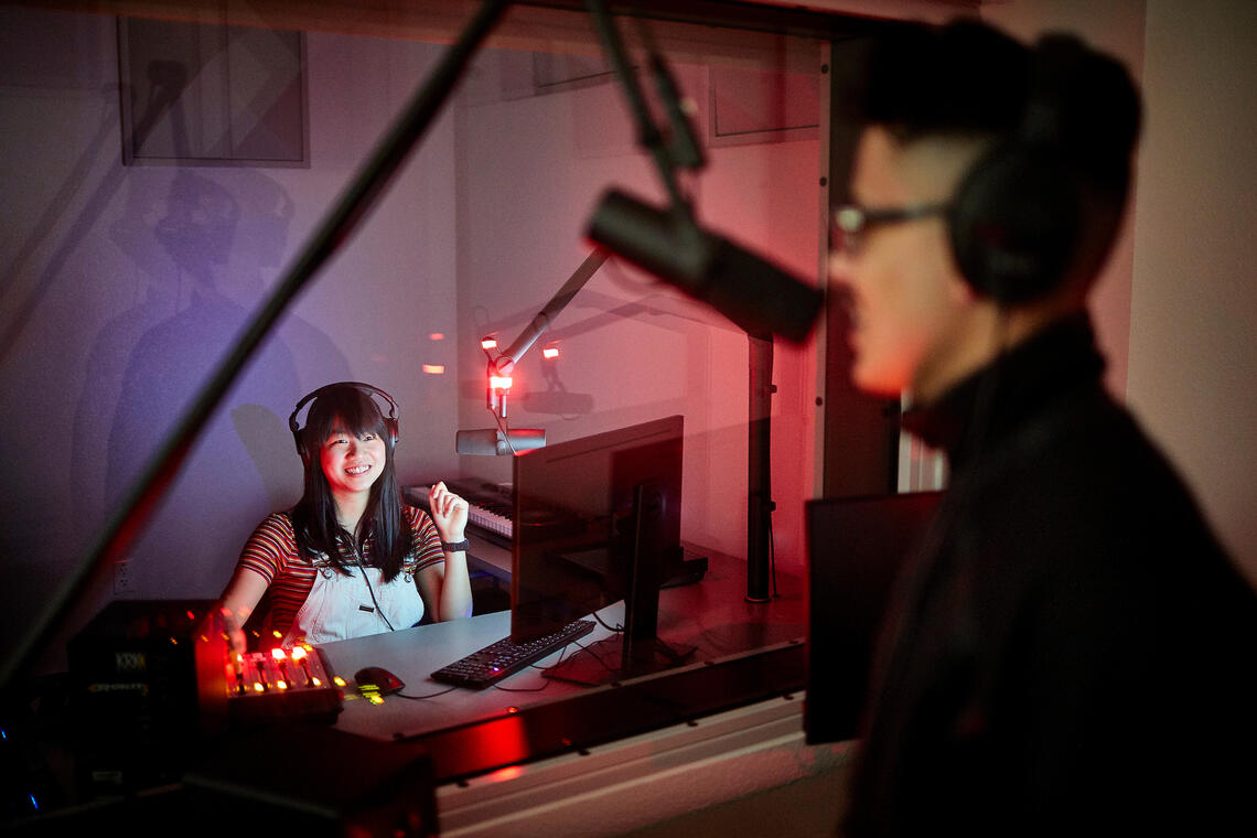 Two people inside a sound studio booth