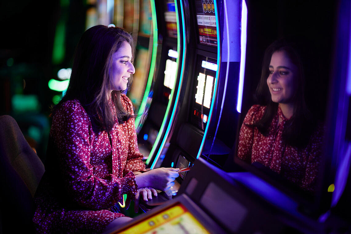 A woman uses a slot machine in a casino