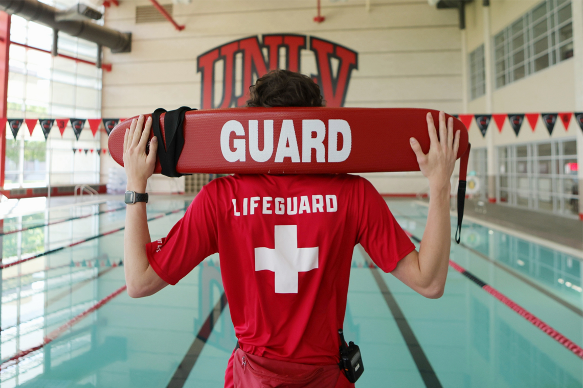 A lifeguard holding up a foam board