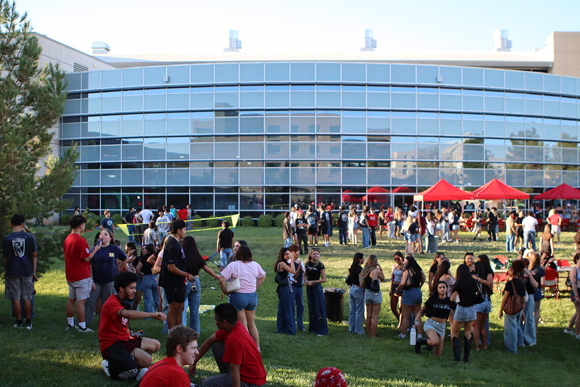 Students gather outside on the campus lawn of Student Recreation and Wellness Center