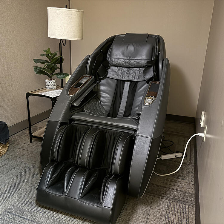 Massage chair with a side table, plant, and lamp beside it.