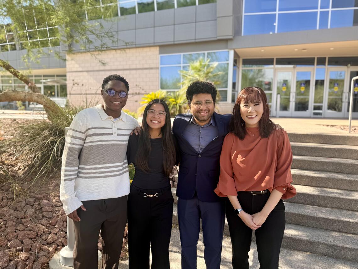 4 people grouped together for a photo in front of the Student Recreation & Wellness Center