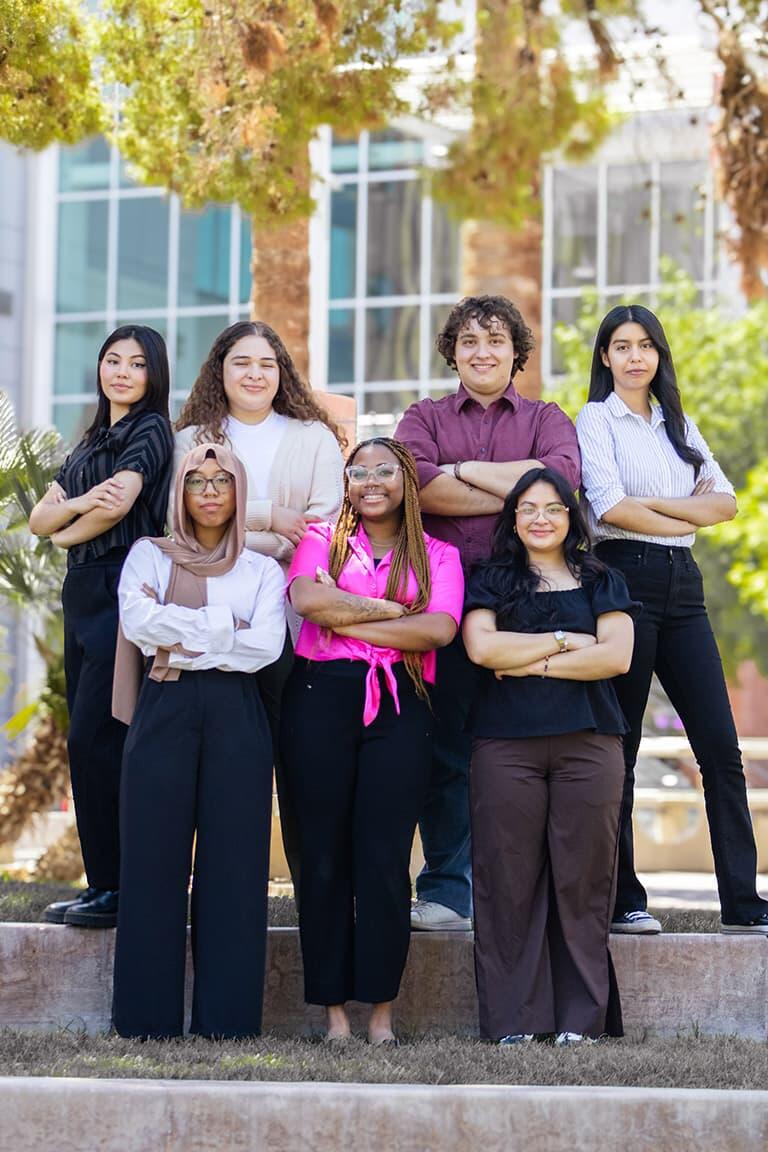 Group of seven posing with crossed arms