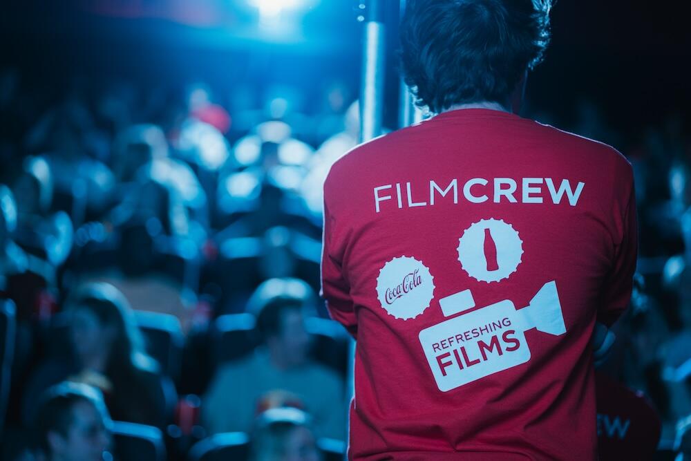 person with back to camera and a shirt that says Film Crew, Cocoa Cola Refreshing Films