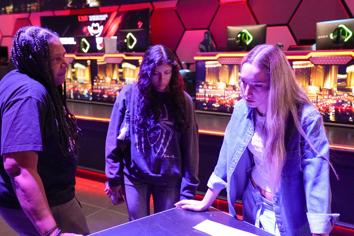 Three students talking to each other at a table