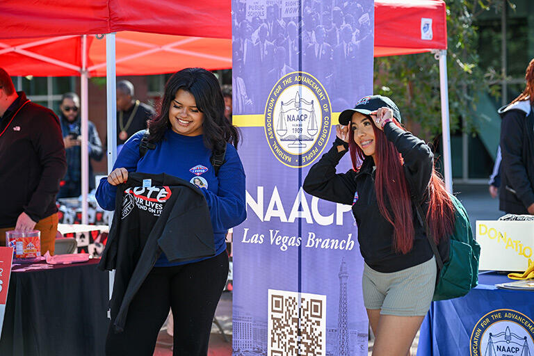 Two students stand near a NAACP information booth