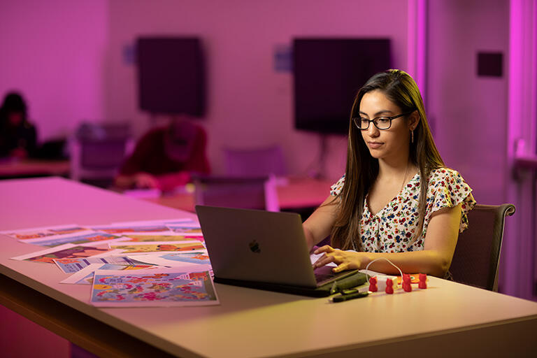 Female student typing on a laptop