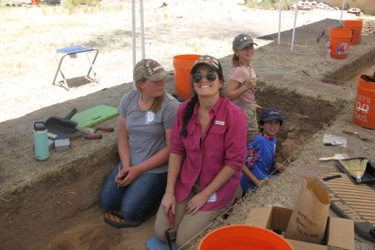 Archaeology students sitting in an excavation ground