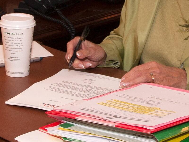 A faculty member reviewing files and notes from a organized folder.