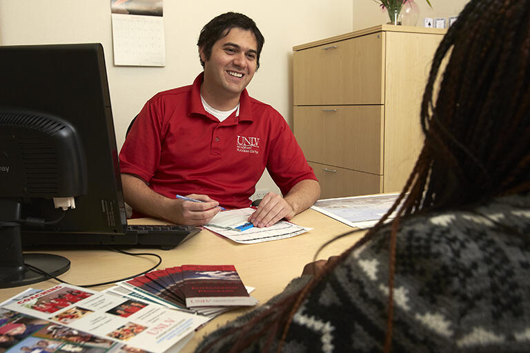 academic advisor helping student at office desk