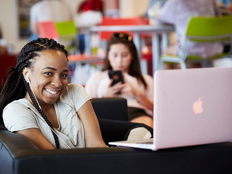 A student smiling in front of her laptop
