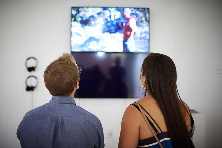 Two people look at a video 