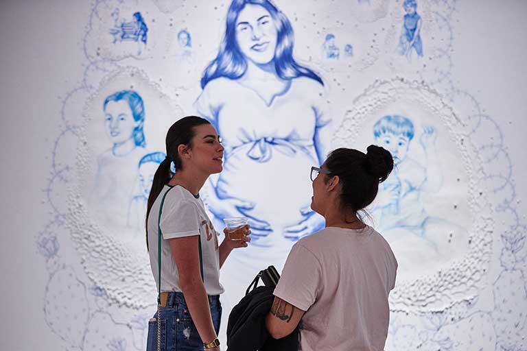 Two students discuss a painting