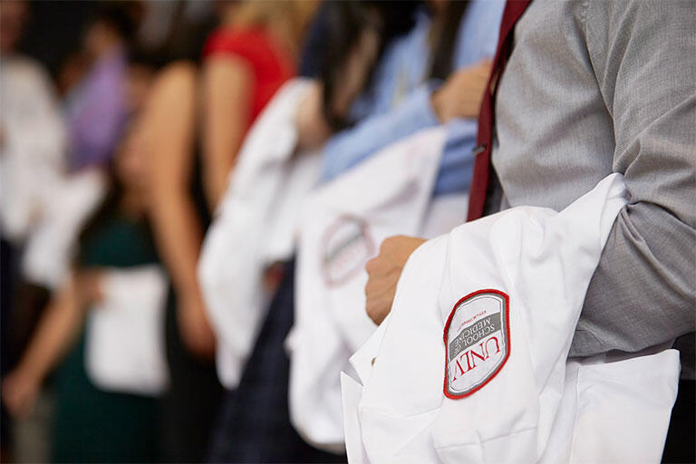 Students taking their oath and receiving their first white coat and stethoscope in the White Coat Ceremony