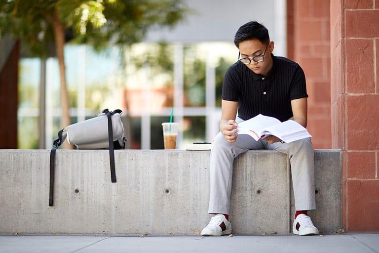 Young man studying outside