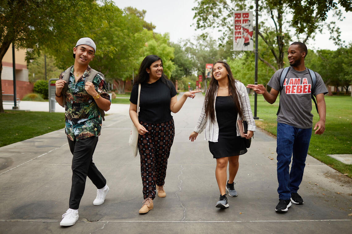 Four students walking on campus 